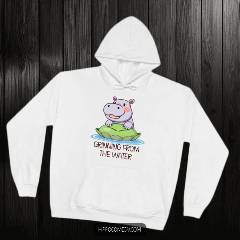 Funny hoodie design of an excited hippo with a huge smile, its head popping up from behind a very large lily pad.