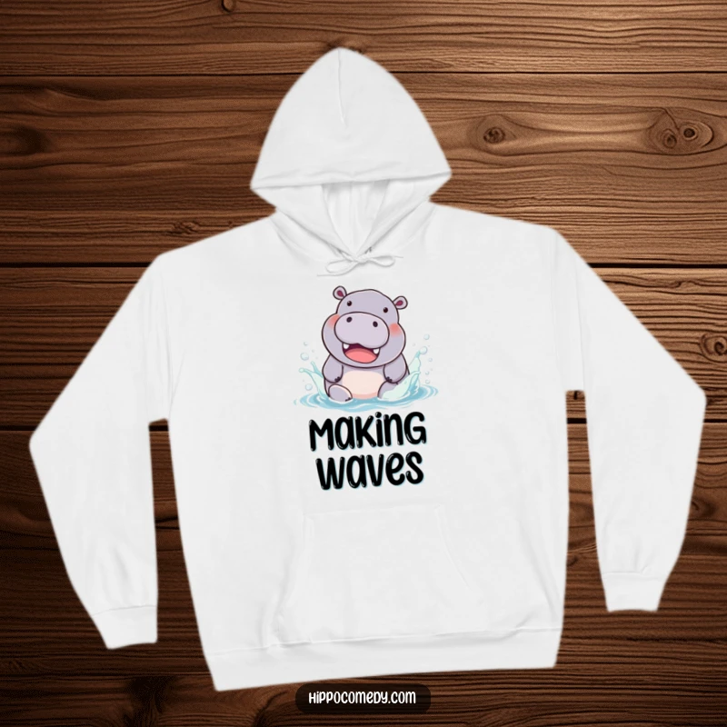 Funny Hoodie: A chubby hippopotamus with a huge smile, splashing playfully in a pool of rainbow water.