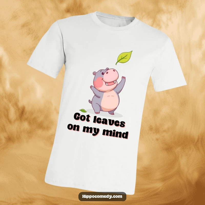 Funny t-shirt depicting a determined hippopotamus in mid-leap, humorously trying to catch a falling leaf.