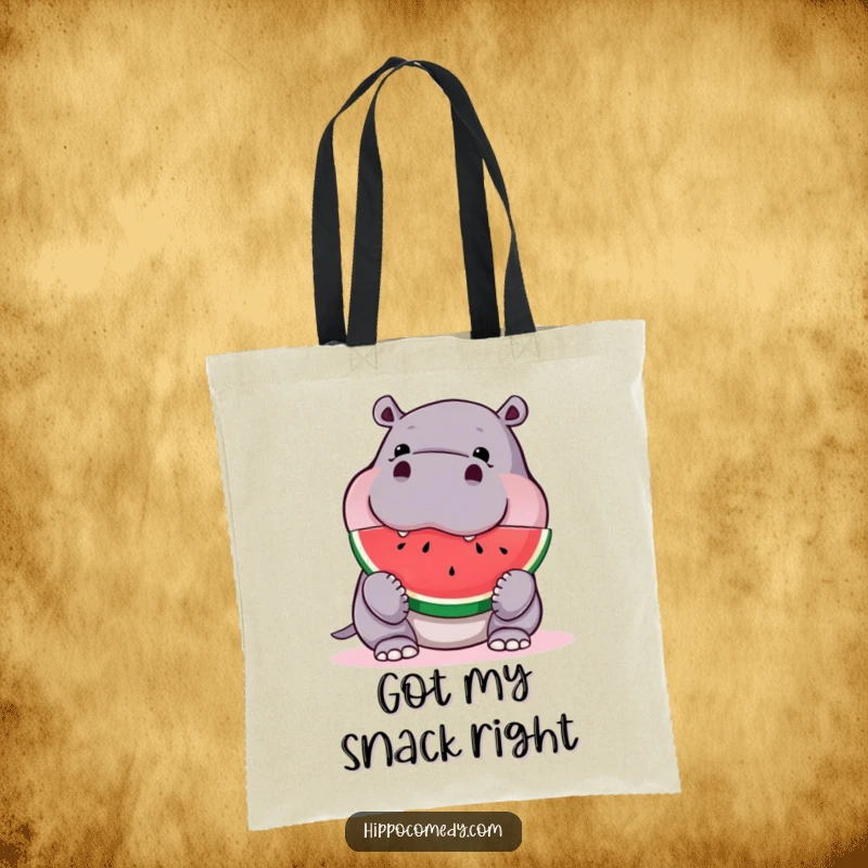 Funny hippo tote bag, happily chowing down on a large slice of watermelon, showcasing a relatable love for snacks.